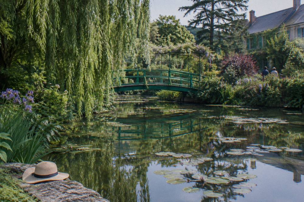 The Japanese bridge over the water lily pond with willows reflected in still water