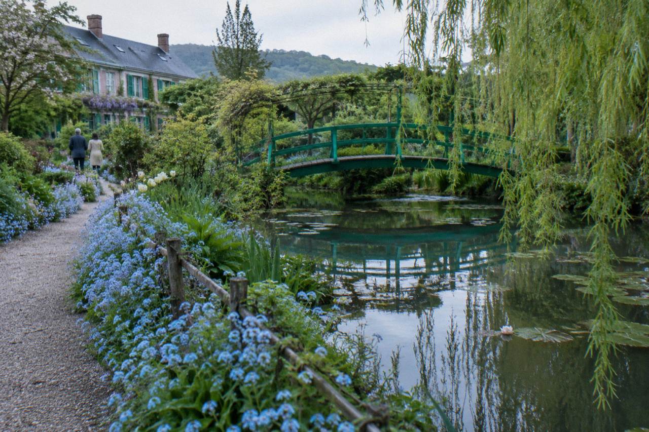 Flower-lined path leading to the Japanese bridge over Monet's water lily pond at Giverny