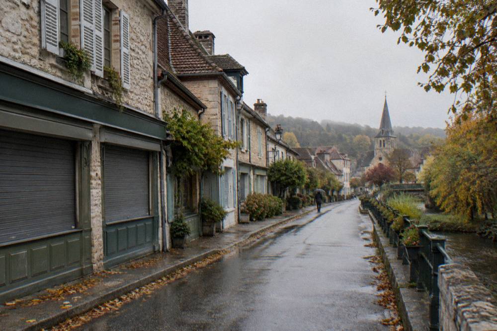 A row of stone houses and shuttered storefronts along the main street of Giverny village