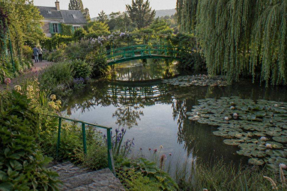 The Japanese bridge over the water lily pond, with willows and reflections in the still water