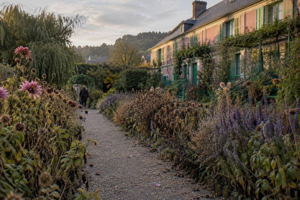 Long flower borders of the Clos Normand garden leading toward Monet's pink house