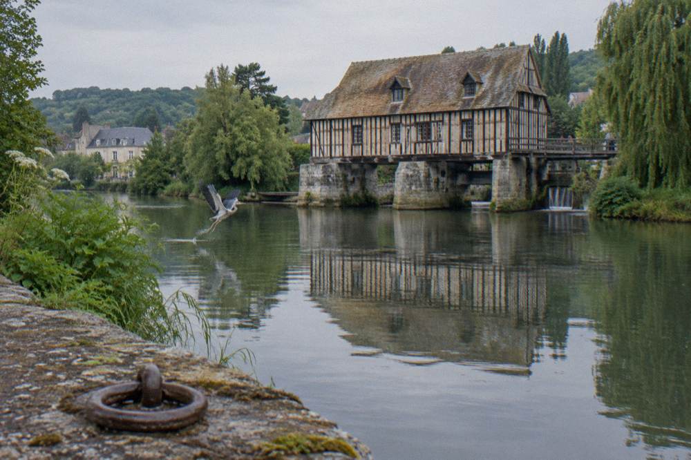 Old wooden mill of Vernon reflected in the Seine river