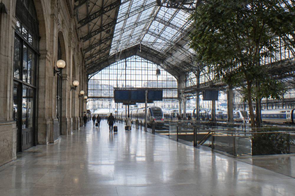 A ticket hall in a Paris railway station with departure boards above the platforms