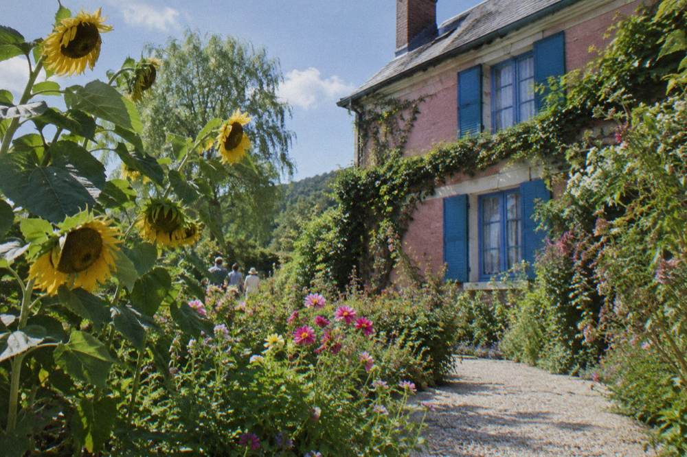 The flower garden and pink facade of Monet's house seen from the Clos Normand