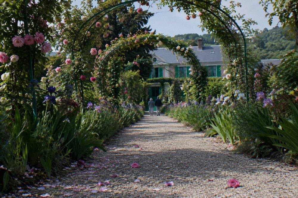 The Grande Allée of Monet's garden bordered by flower beds leading toward the house