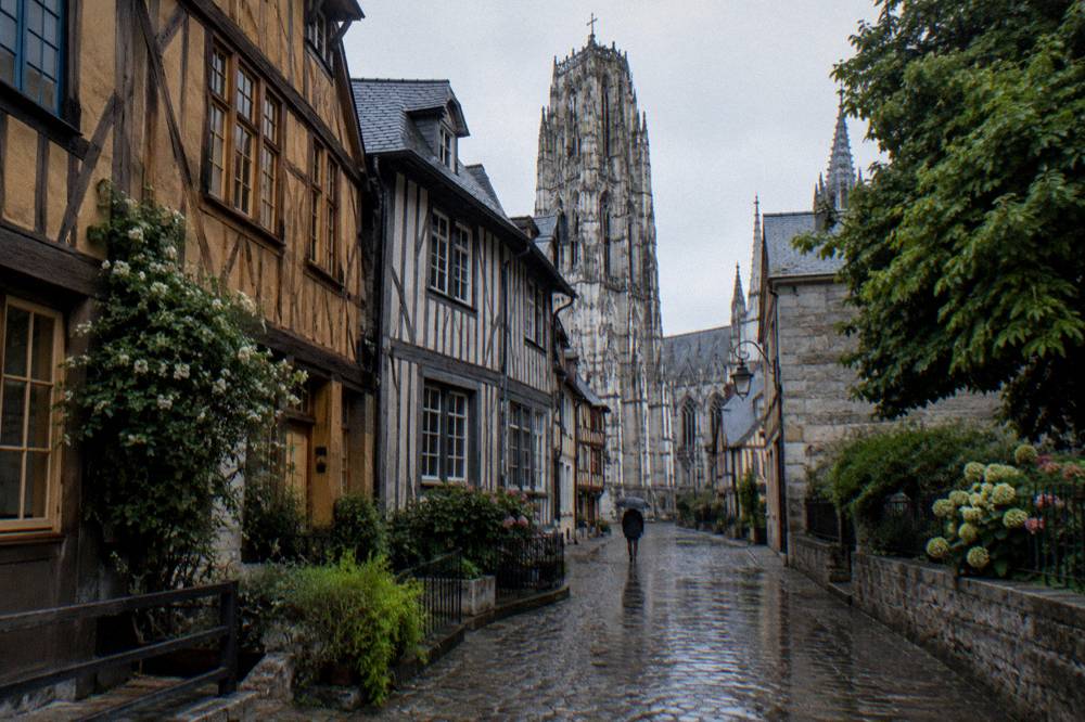 Half-timbered houses on a street in Rouen under a gray sky