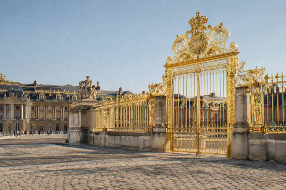 Sunlight on the gilded gate and courtyard of the Palace of Versailles