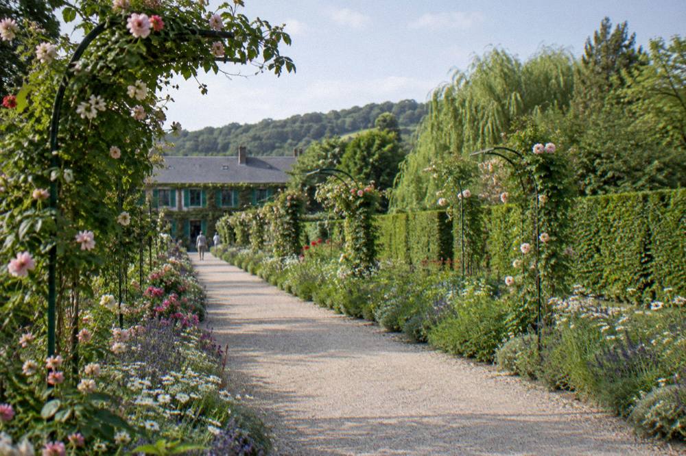 Formal flower garden with long allée and arched metal rose supports