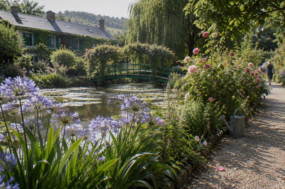 Flower border and green footbridge in Monet's water garden