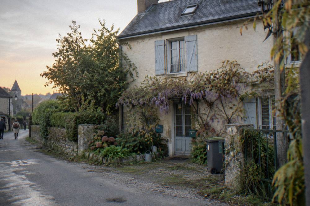 Wisteria-covered stone facade of a small inn in a Normandy village