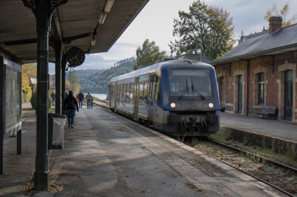 Railway platform at Vernon station with a regional train at morning light